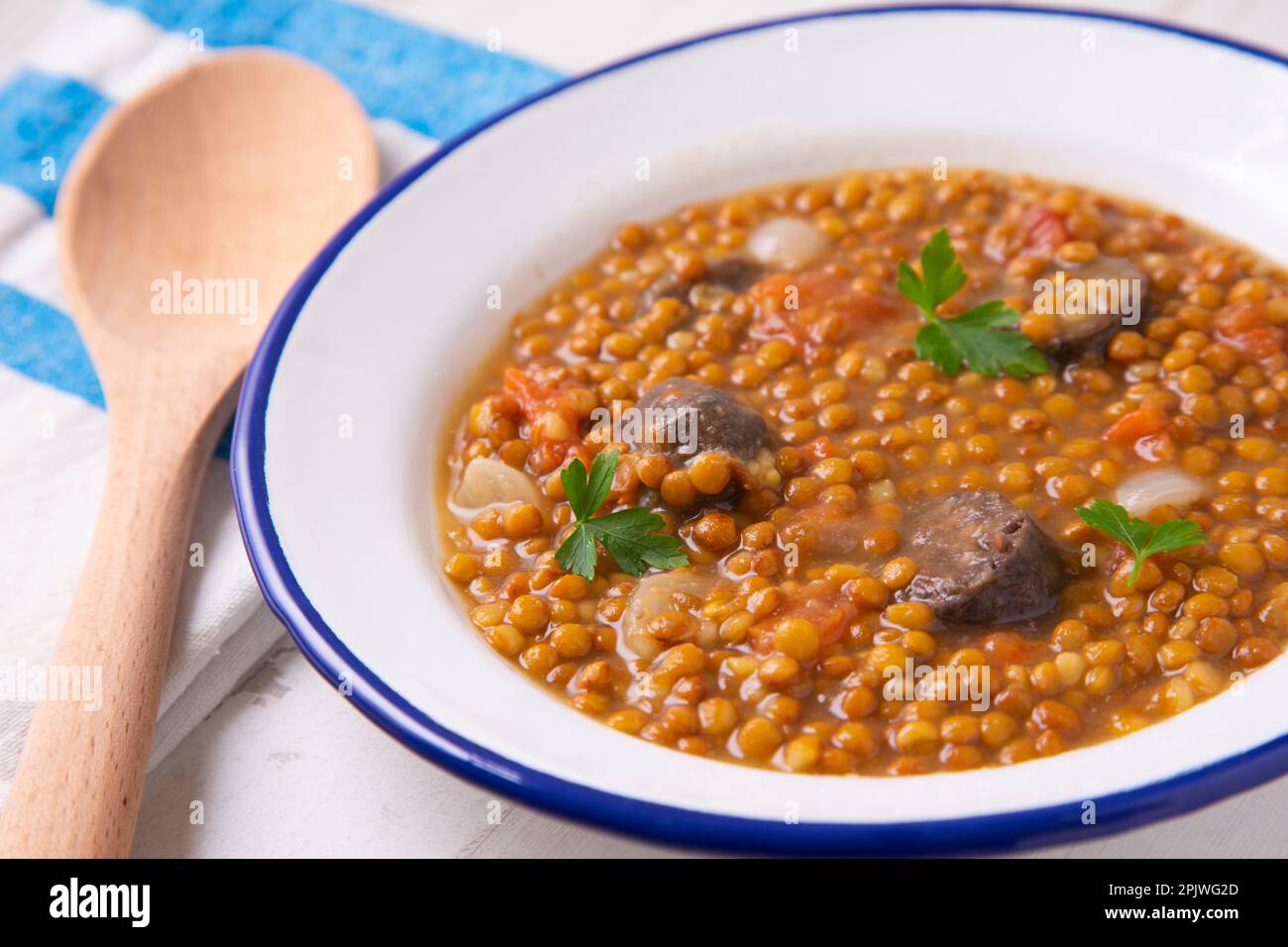 Linsenschale mit Kartoffeln, Chorizo und schwarzem Pudding. Traditioneller spanischer Linseneintopf mit Gemüse. Stockfoto