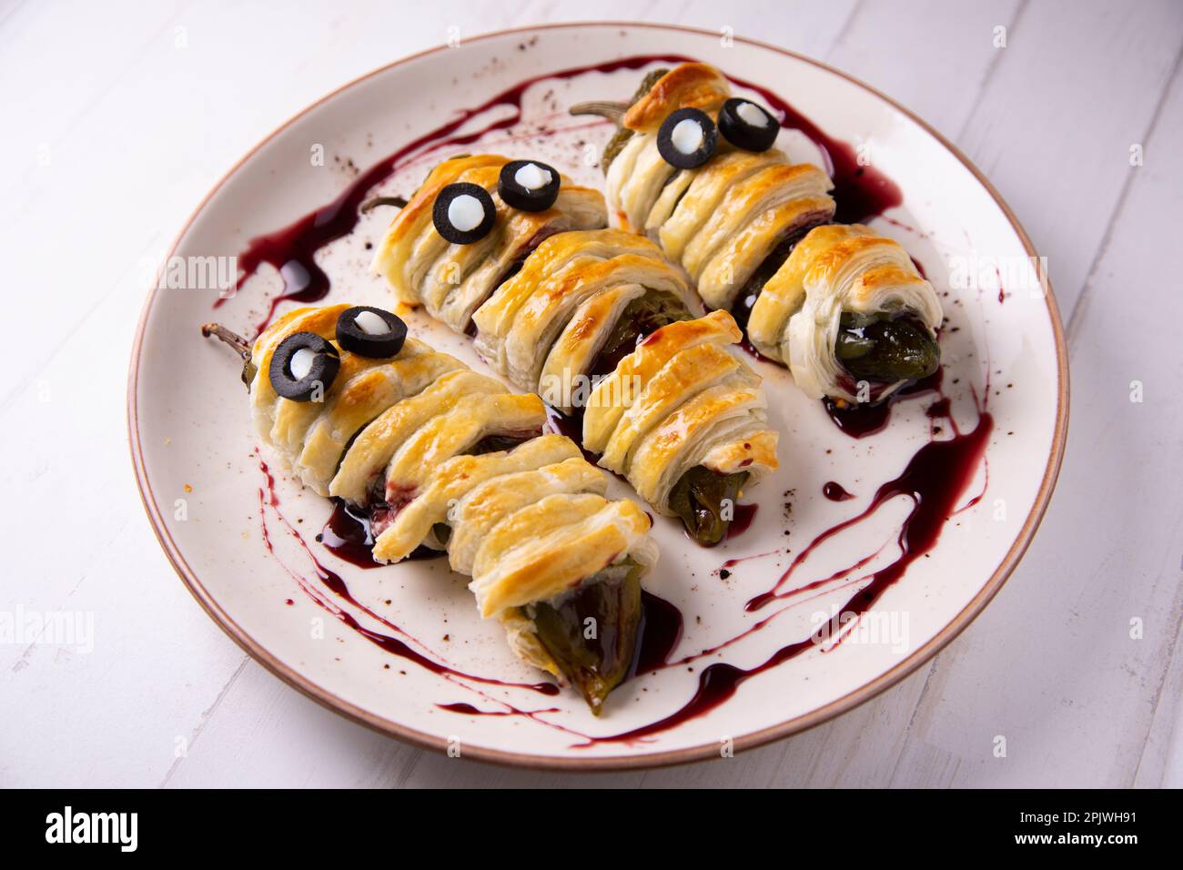 Halloween-Rezept. Gebratene grüne Paprika in Mumienform. Stockfoto