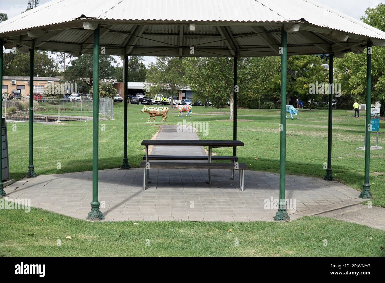 Ein Picknickbereich mit Tisch und Stühlen in einem öffentlichen Park mit grünem Gras. Stockfoto