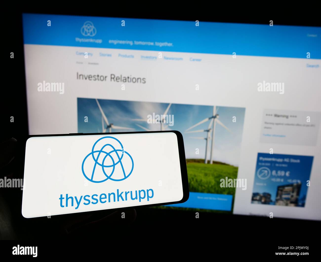 Person, die ein Mobiltelefon mit Logo des deutschen Konglomerats ThyssenKrupp AG auf dem Bildschirm vor der Webseite hält. Konzentrieren Sie sich auf das Display des Telefons. Stockfoto