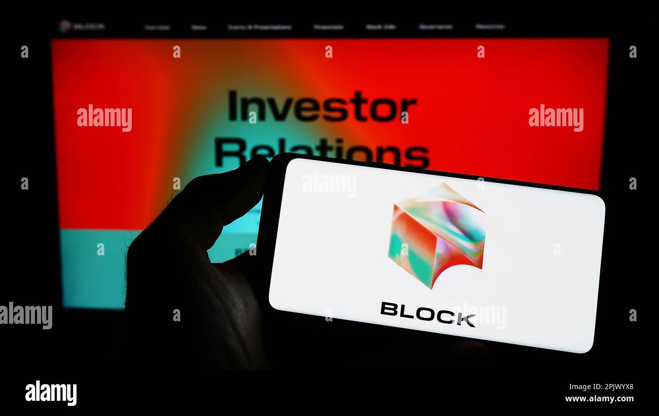 Person, die ein Mobiltelefon mit dem Logo des Technologieunternehmens Block Inc. Auf dem Bildschirm vor der Unternehmenswebseite hält. Konzentrieren Sie sich auf das Display des Telefons. Stockfoto