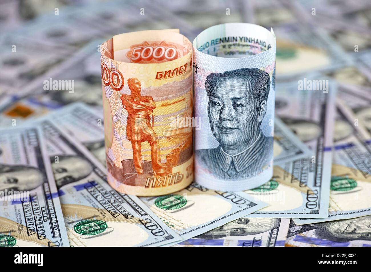 Chinesische Yuan-Banknote und russischer Rubel mit US-Dollar-Hintergrund. Konzept der strategischen Partnerschaft zwischen China und Russland, wirtschaftlich Stockfoto