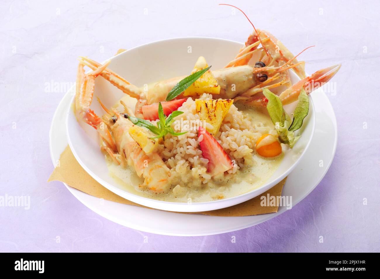Ein Risotto-Gericht mit frischem Obst und gebratenen Scampi. Stockfoto