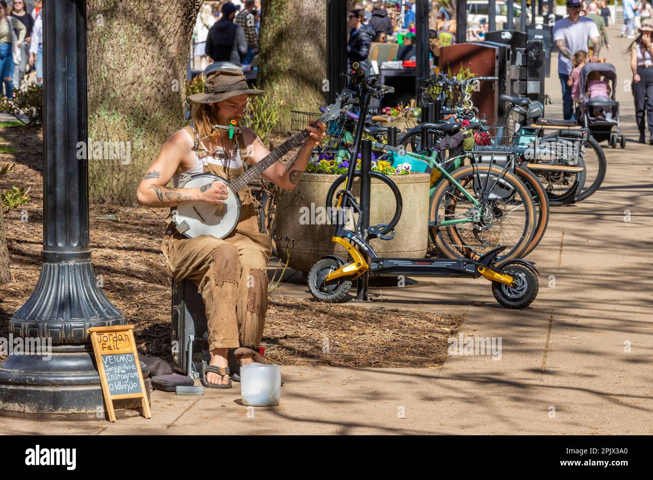 Knoxville, Tennessee, USA - 25. März 2023: Straßenkünstler spielt ein Kazoo und ein Banjo. Im Stadtzentrum. Stockfoto