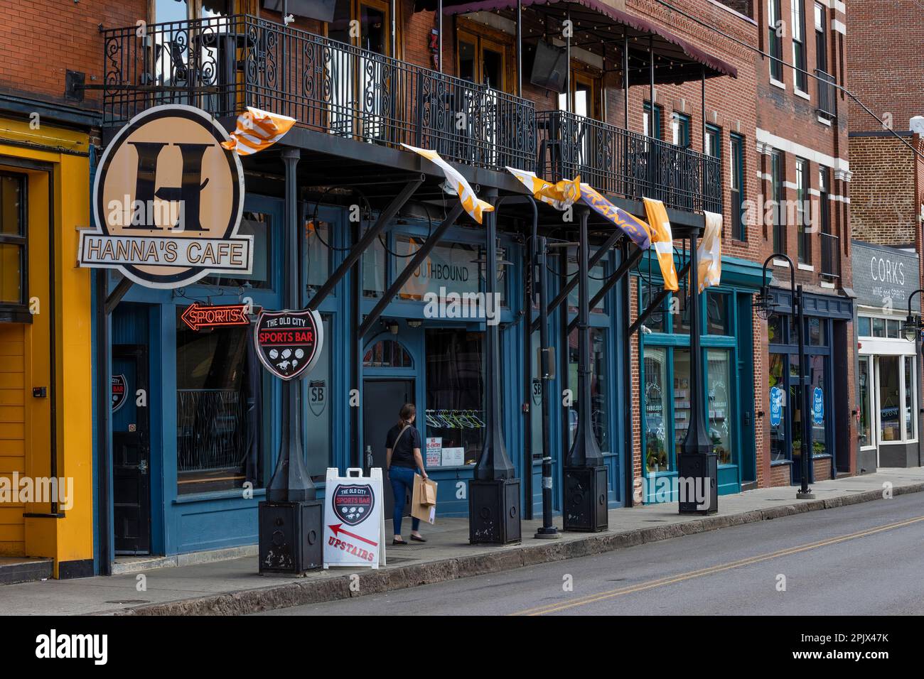 Knoxville, Tennessee, USA - 25. März 2023: Old City Street, wo eine Person auf dem Gehweg vor dem Laden spaziert. Stockfoto