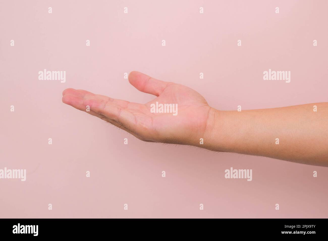 Nahaufnahme männliche Hand, die bereit ist, zu helfen oder zu empfangen, isoliert auf pinkfarbenem Hintergrund. Helfende Hand zur Rettung ausgestreckt. Stockfoto