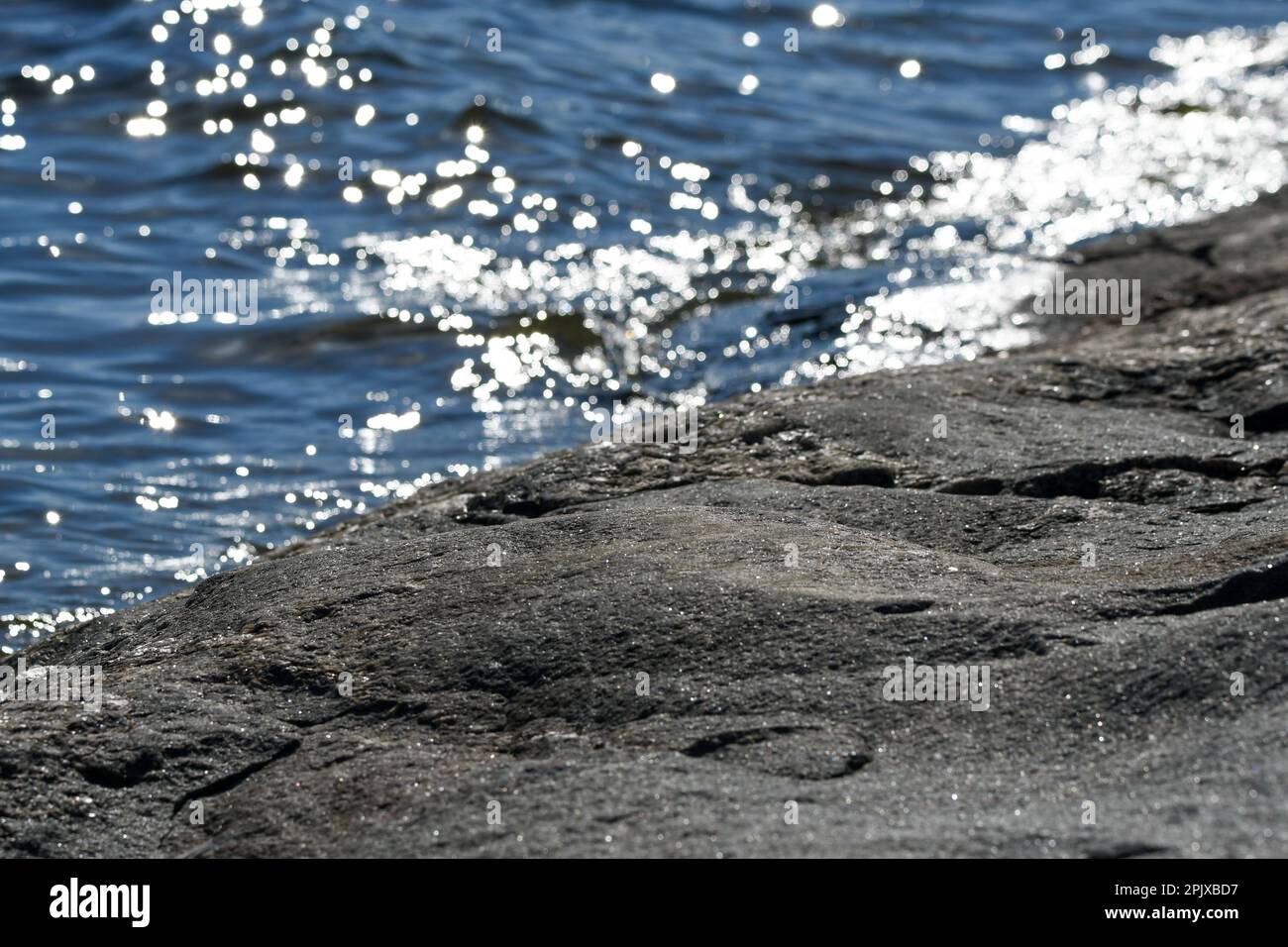 Ripple-Effekt auf die felsige Insel im finnischen Archipel an einem sonnigen Sommertag Stockfoto