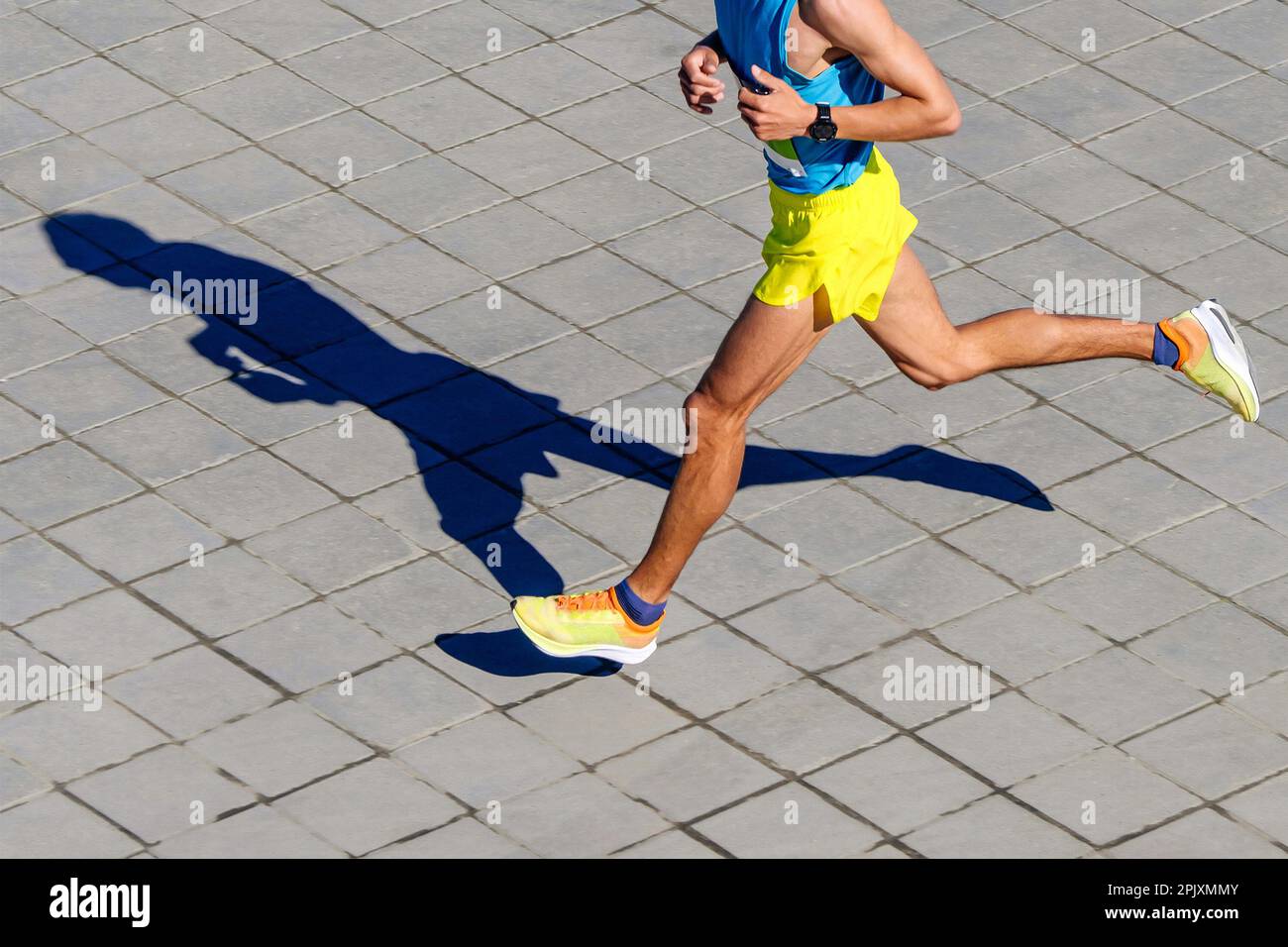 Draufsicht männlicher Läufer läuft Marathonrennen, Schattenjogger auf Pflasterplatten, Timer auf der Hand des Sportlers Stockfoto