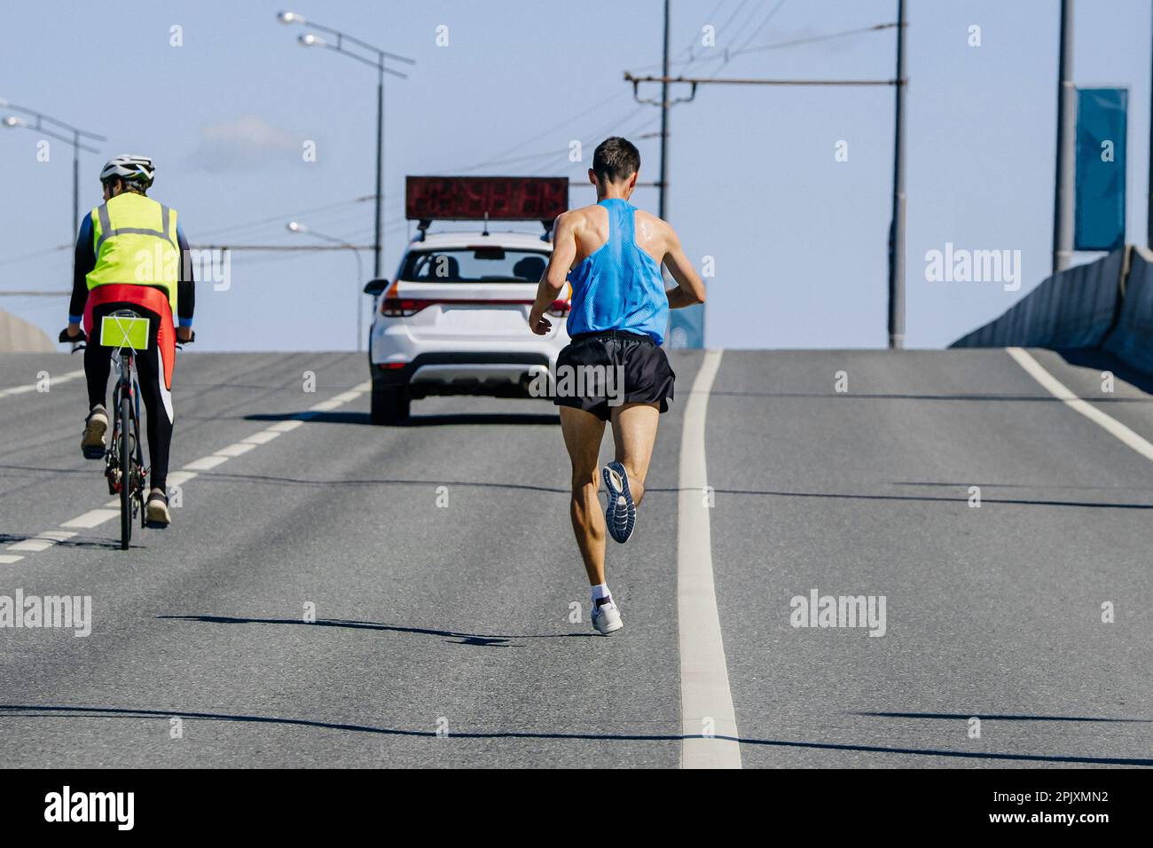 Männermarathonrennen für Pace Car, männlicher Sportler joggt bergauf, Ausdauersportwettbewerb Stockfoto