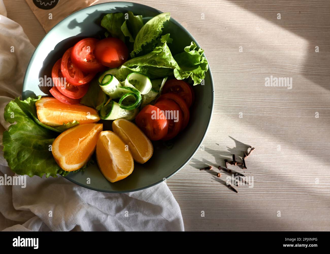 Salatzubereitung, Draufsicht von frischem Obst und Gemüse neben Phonendoskop auf hellblauem Holzhintergrund. Konzept des Gesundheitswesens. Ausgewogene Ernährung Stockfoto