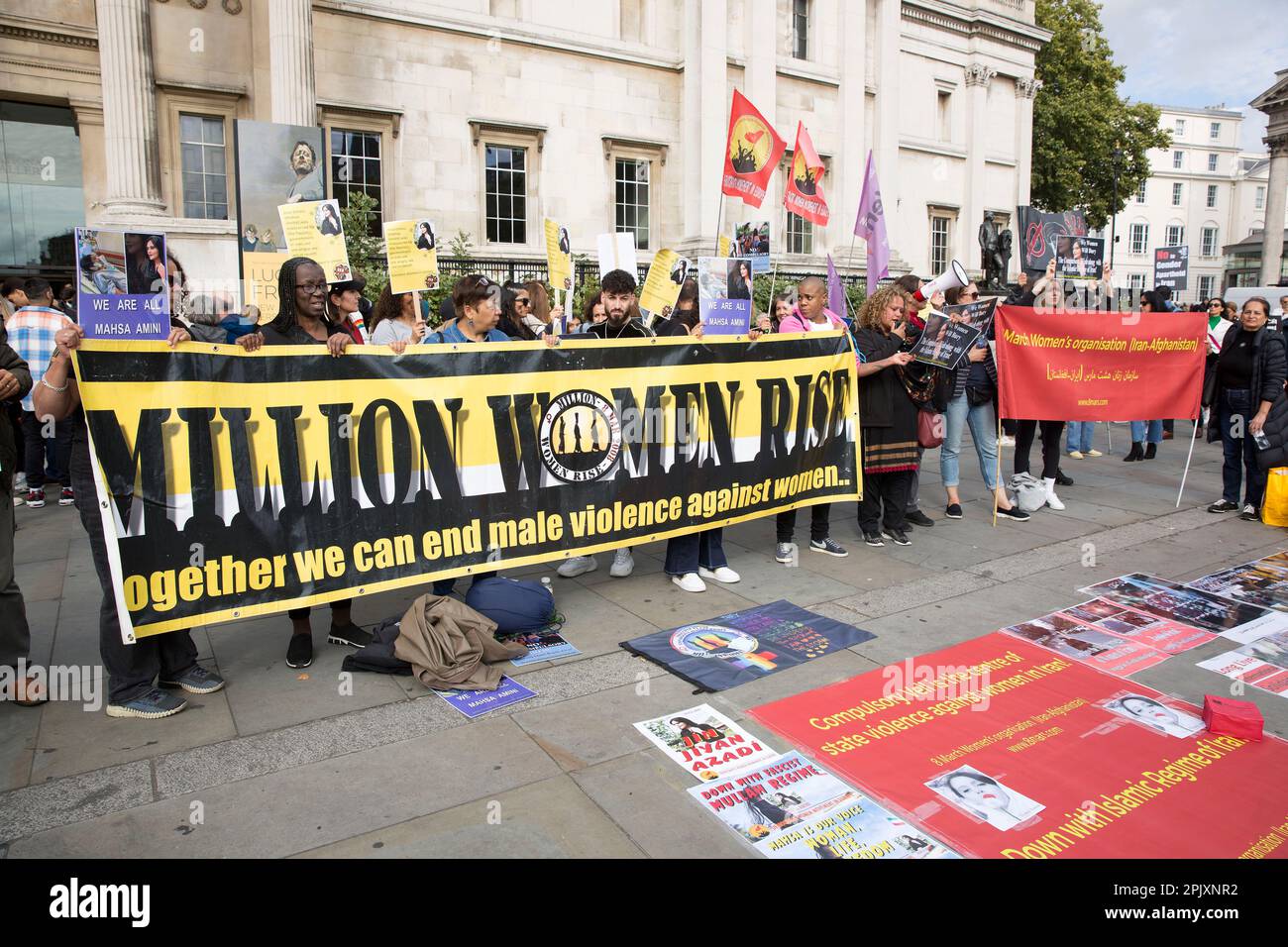 Die Teilnehmer halten ein Banner, in dem sie ein Ende der männlichen Gewalt gegen Frauen in London fordern, während sich Menschen für die Freiheit der Frauen im Iran versammeln. Stockfoto