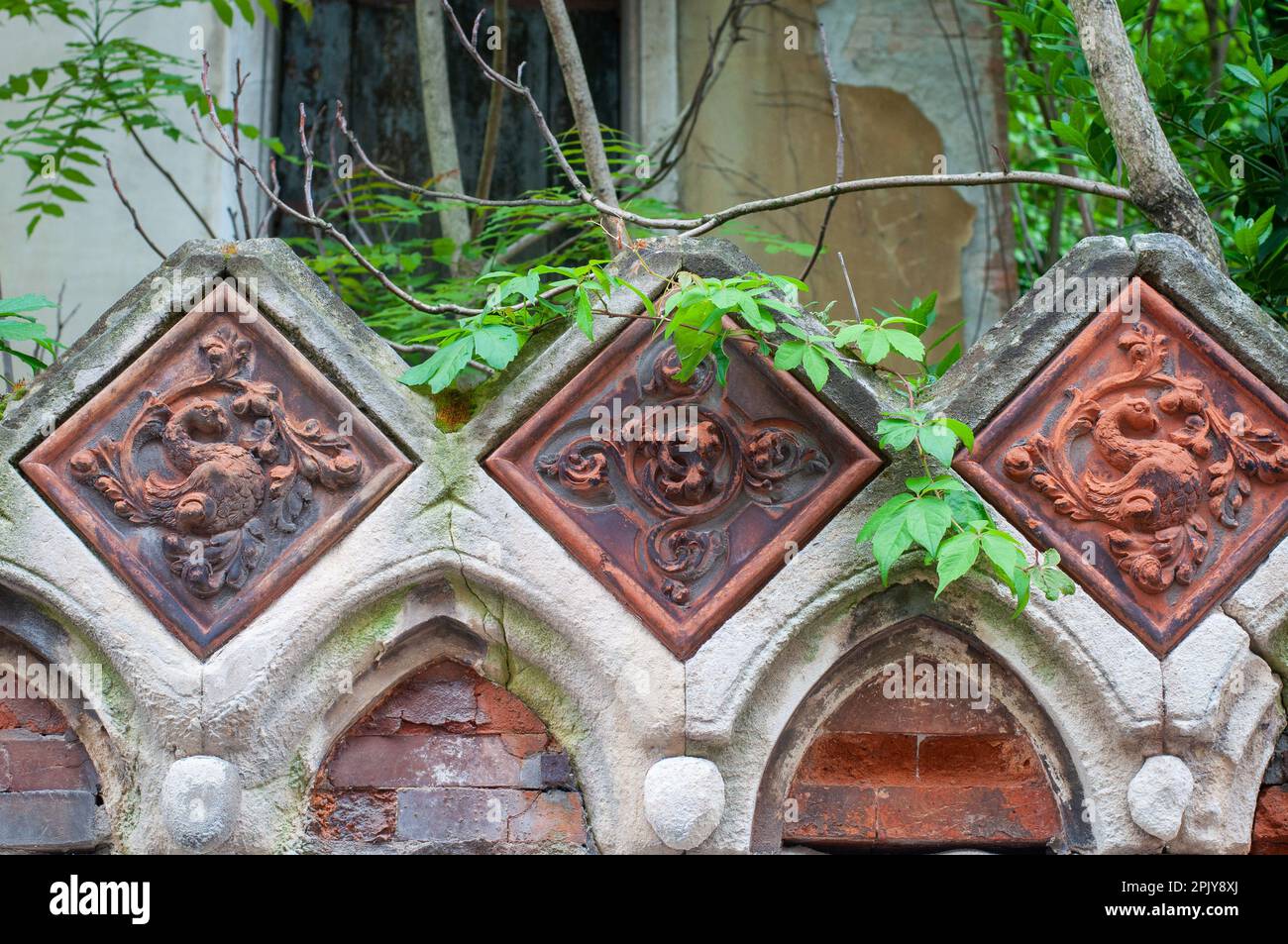 Dekorative Relief mit Blumenschmuck in Terrakotta. Dekorativer tiel. Verlassene Architektur. Außen. Stockfoto