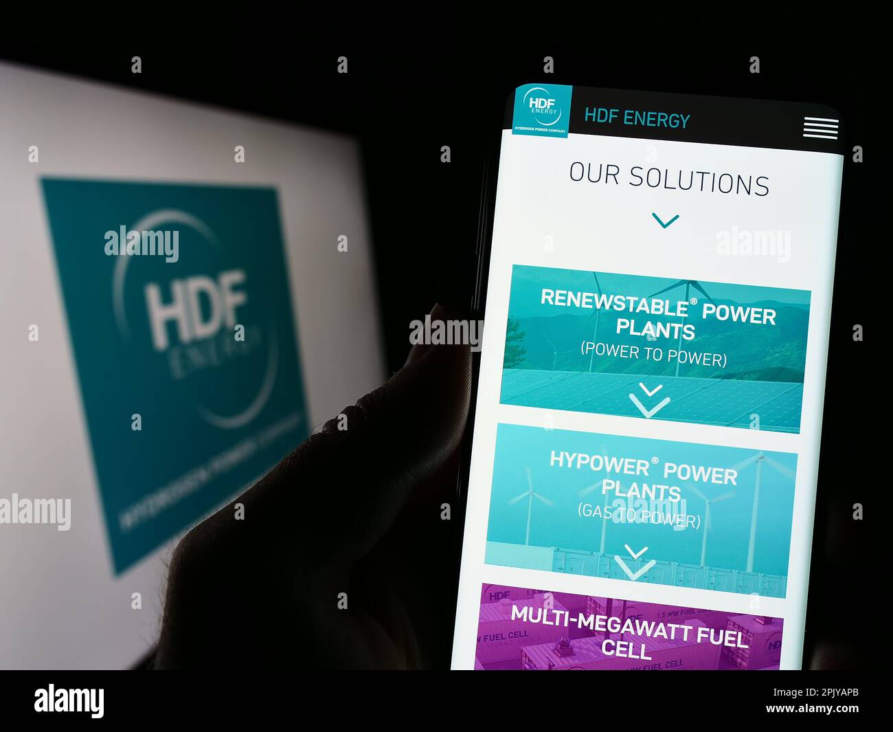 Person, die ein Smartphone mit der Website des französischen Wasserstoffunternehmens HDF Energy auf dem Bildschirm vor dem Logo hält. Konzentrieren Sie sich auf die Mitte des Telefondisplays. Stockfoto