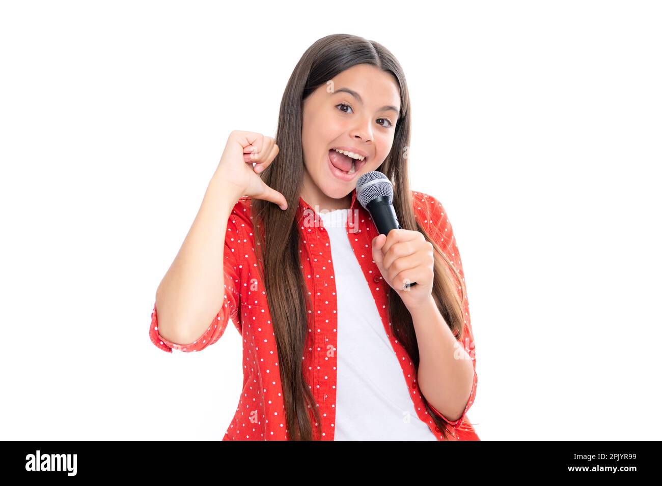 Porträt eines emotional erstaunten Teenagers mit Mikrofon, das vor weißem Hintergrund singt. Singendes, liebes Sängermädchen hält das Mikrofon Stockfoto