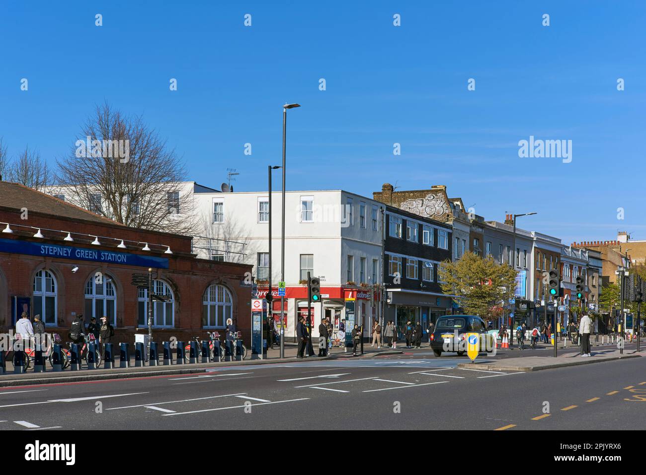 Stepney Green Tube Station und Mile End Road, East London, Großbritannien, mit Blick nach Osten, mit Fußgängern Stockfoto