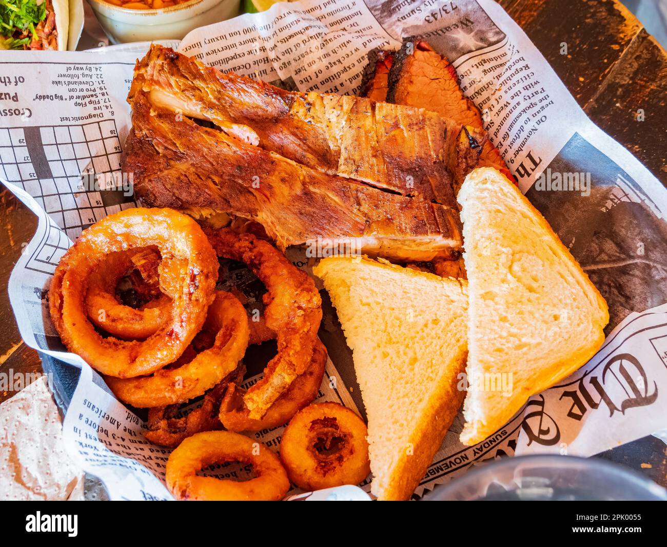 Nahaufnahme von frittierten Zwiebelringen und Schweinerippchen mit Brot in Oklahoma Stockfoto