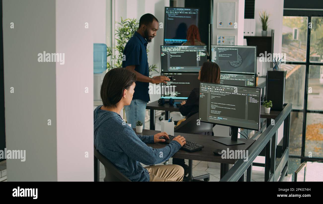 Datenbank-Prograf schreibt Code auf Computer in Software-Firma Büro, zeigt künstliche Intelligenz Algorithmus an. Entwickler codieren Systemschnittstelle und arbeiten mit Datenservern. Stockfoto