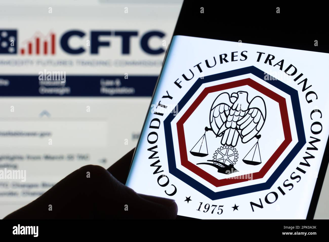 CFTC-Logo der Commodity Futures Trading Commission auf dem Bildschirm des Smartphones, das im Dunkeln in den Händen gehalten wird. Stafford, Großbritannien, 3. April 2023. Stockfoto