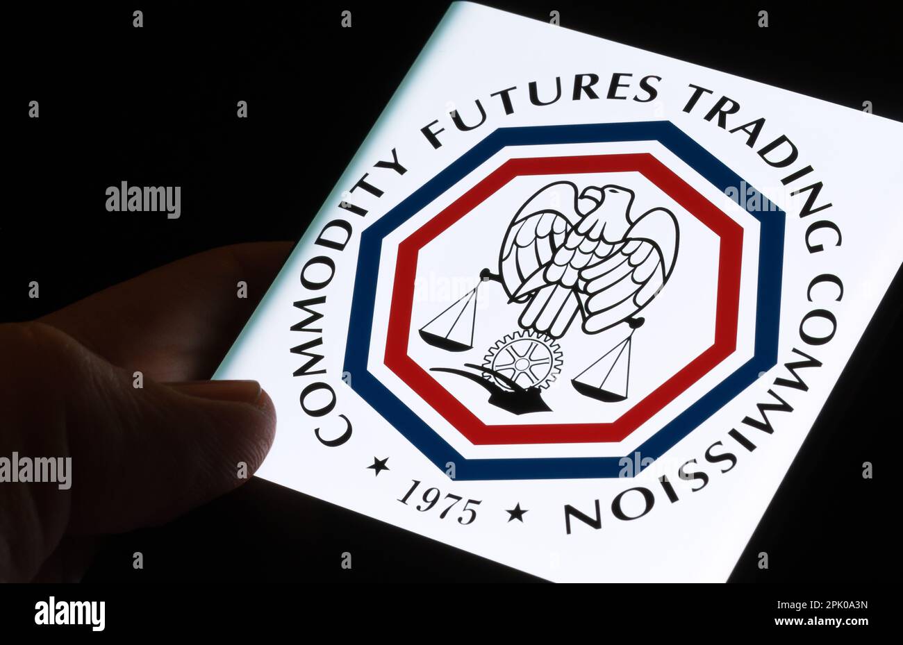 CFTC-Logo der Commodity Futures Trading Commission auf dem Bildschirm des Smartphones, das im Dunkeln in den Händen gehalten wird. Stafford, Großbritannien, 3. April 2023. Stockfoto