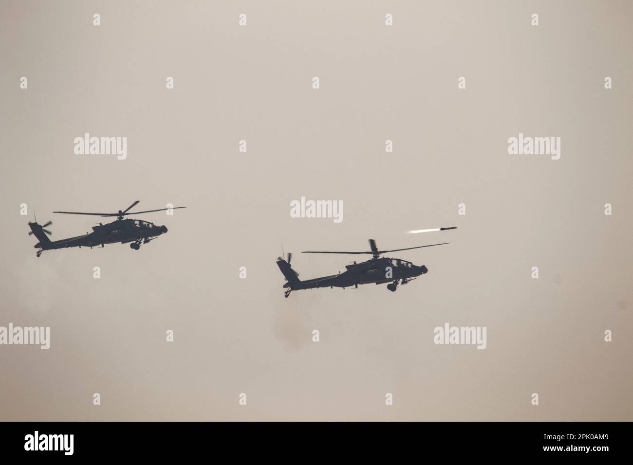 Ein AH-64 Apache von der Task Force Spartan feuert eine Höllenfeuer-Rakete ab, um ein Ziel während Al Tahreer anzugreifen. Bei der multidisziplinären Übung wurden Kräfte von Task Force Spartan, KLF und Großbritannien zusammengeführt, um ihre Fähigkeiten zur Zusammenarbeit während eines Feuerszenarios unter Beweis zu stellen. Die Übung war auch im Vorfeld des Kuwait Liberation Day (USA Armeefoto von Master Sgt. Matthew Keeler) Stockfoto