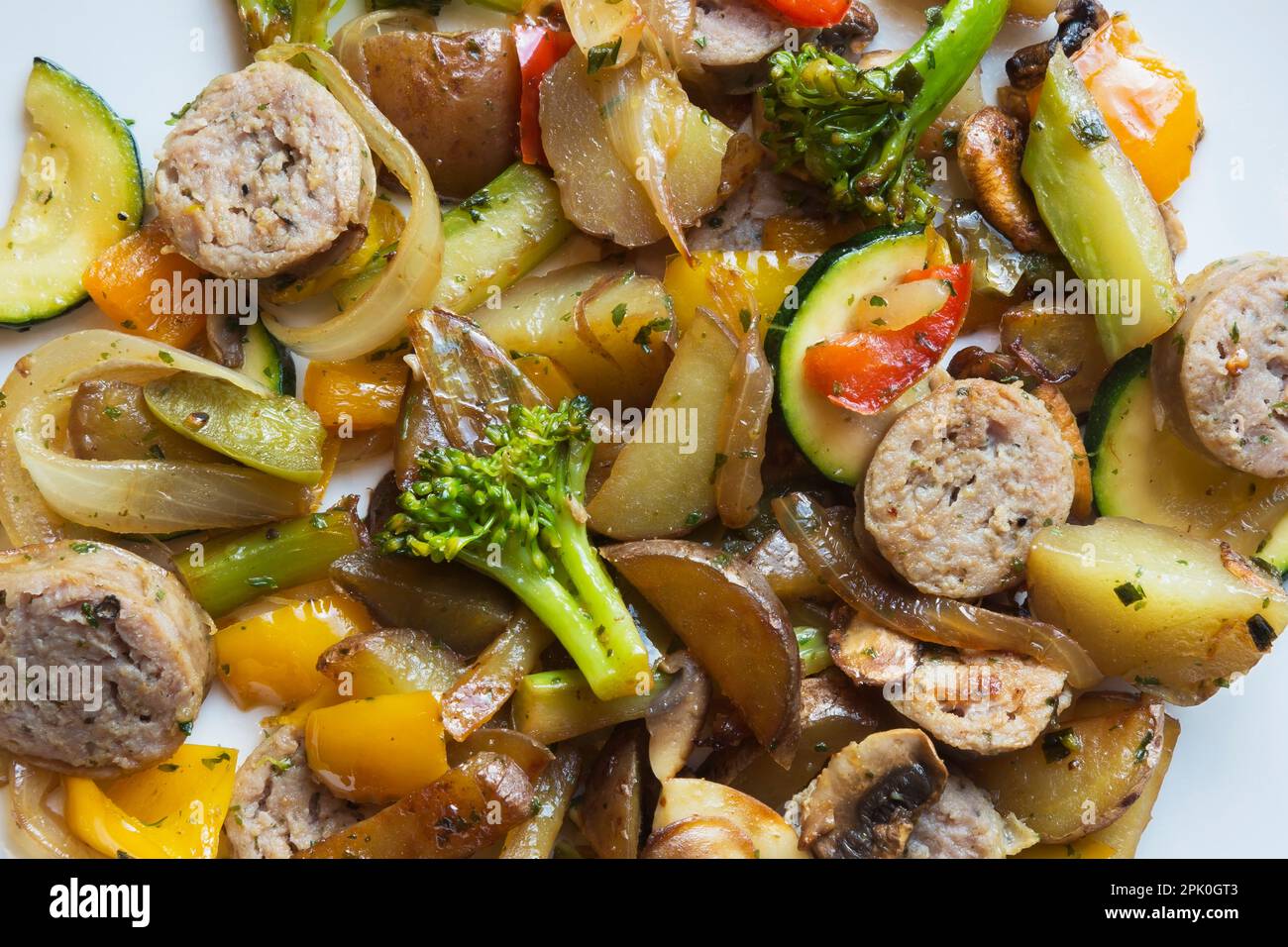 Französisch geröstete Zwiebelwurst mit Kartoffeln, Pilzen, Brokkoli, Zwiebeln, Gelb, Rote, grüne Paprika, Zucchini-Gericht. Stockfoto