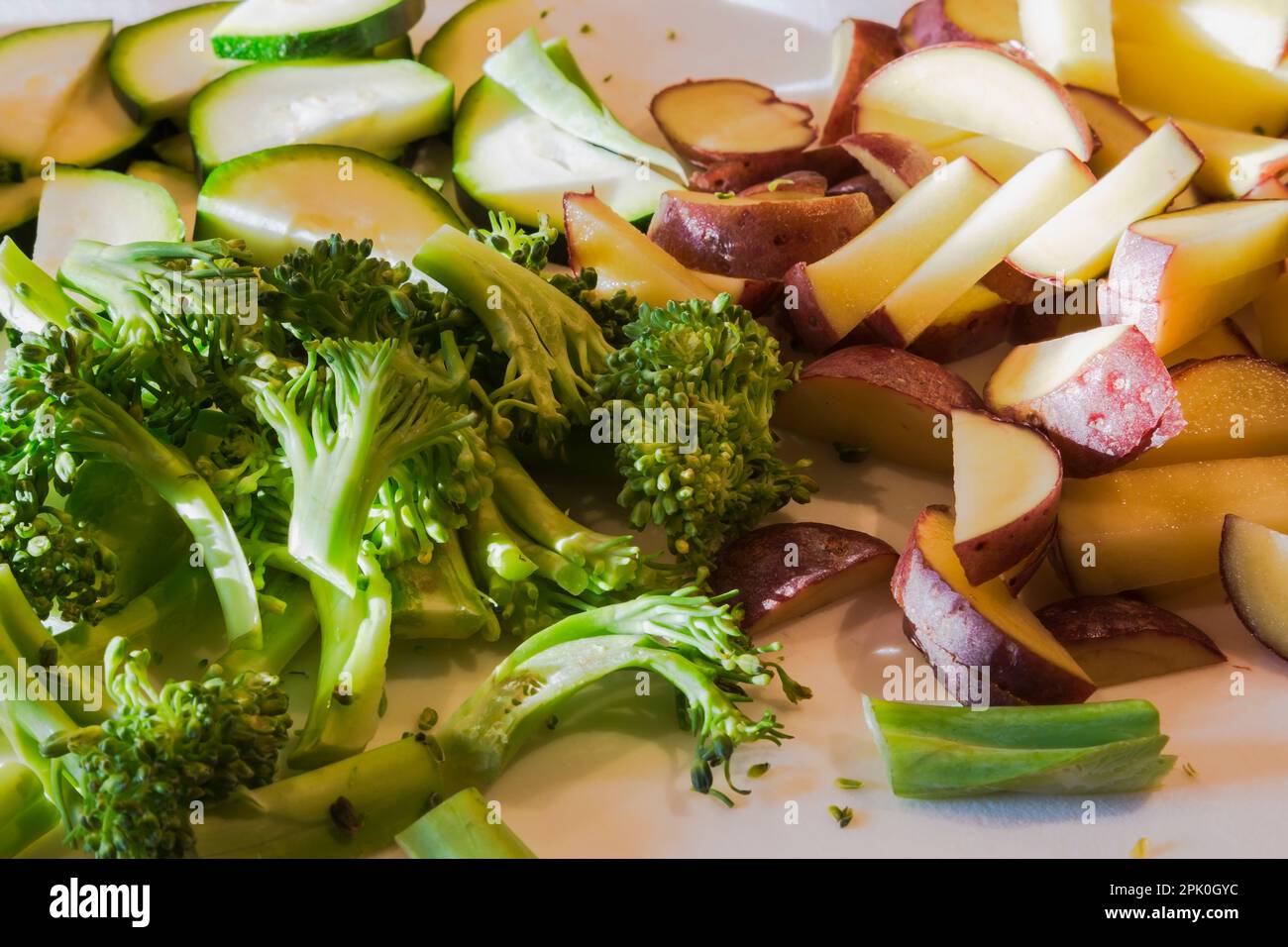 Schneiden Sie Brokkoli, rote Kartoffeln und Zucchini auf dem Schneidebrett. Stockfoto