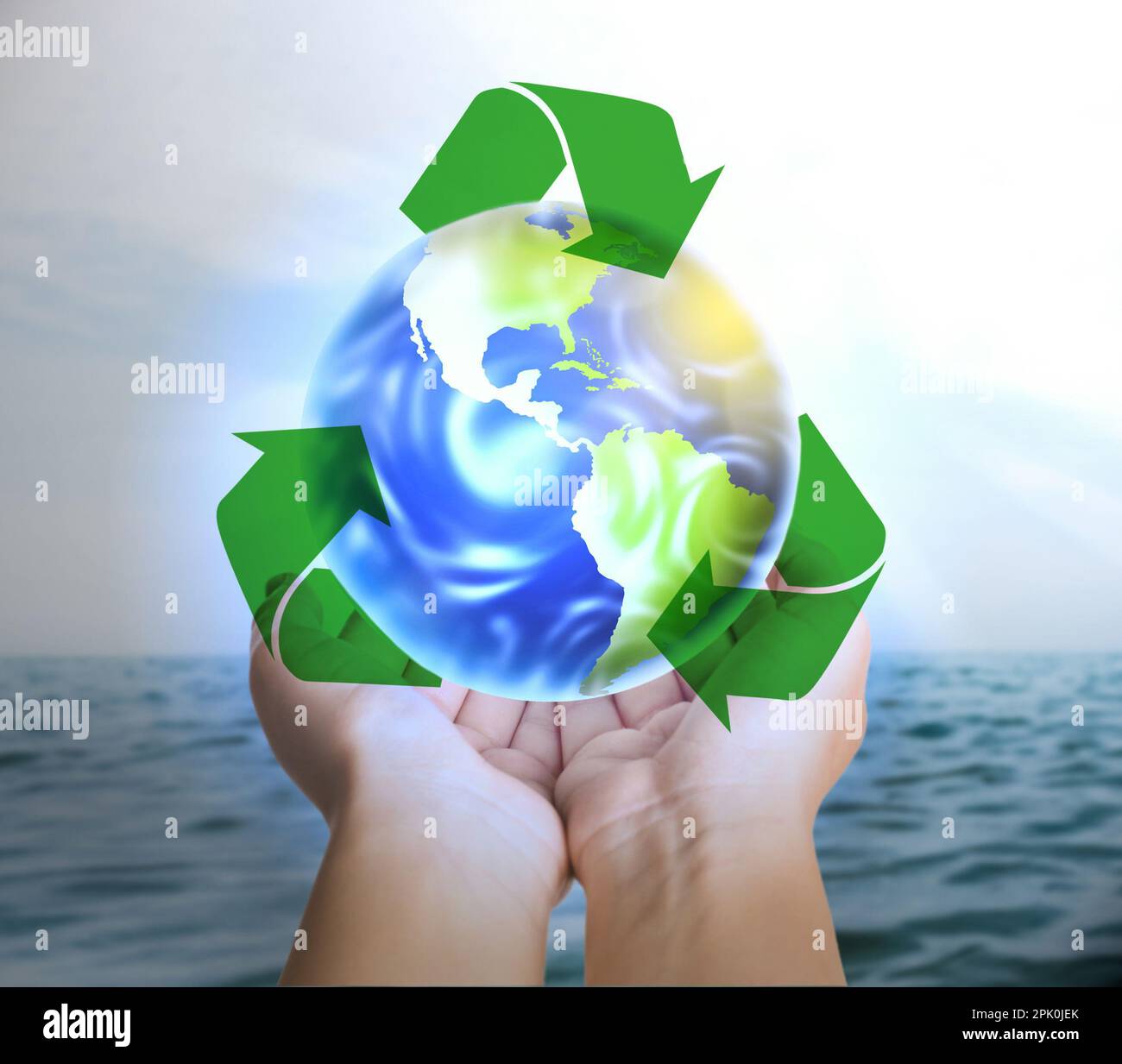 Frau mit virtuellem Bild der Erde und Recycling-Symbol nahe dem Meer, Nahaufnahme Stockfoto