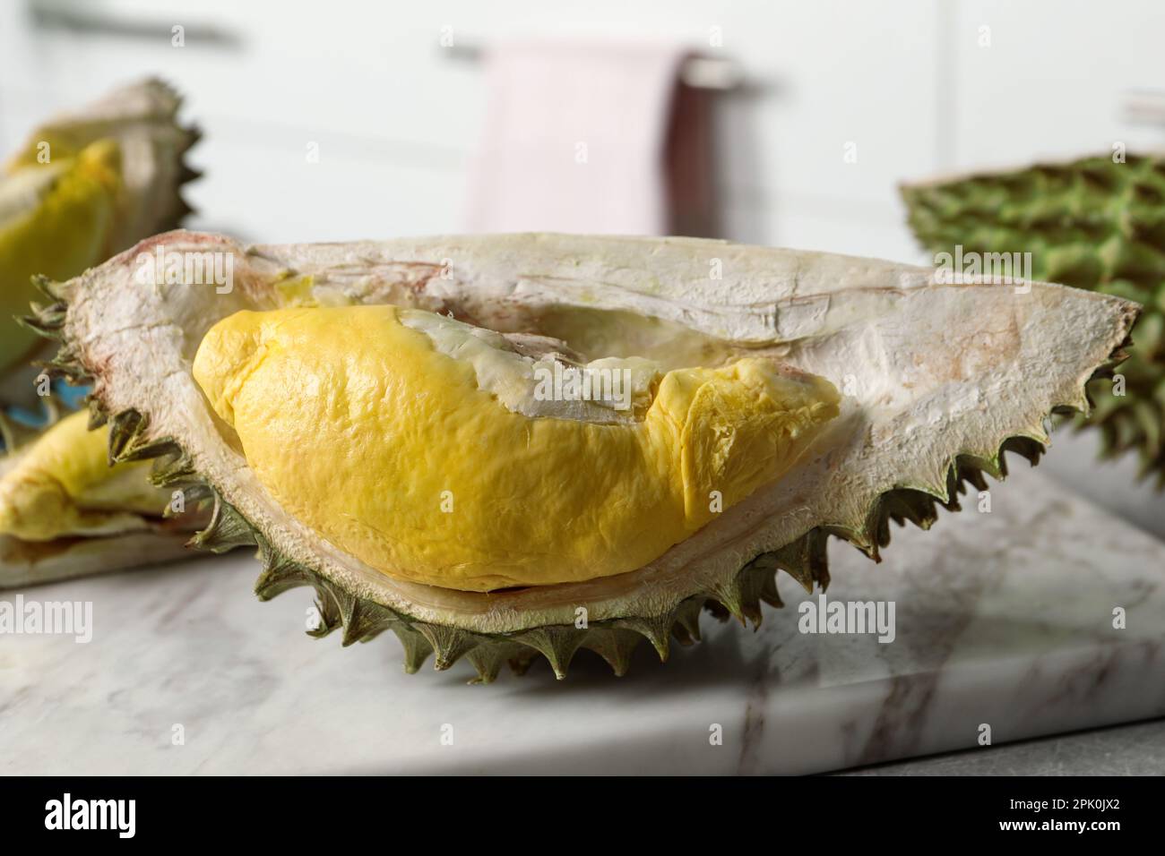 Ein Stück frische, reife Durian auf einem grauen Tisch in der Küche, Nahaufnahme Stockfoto