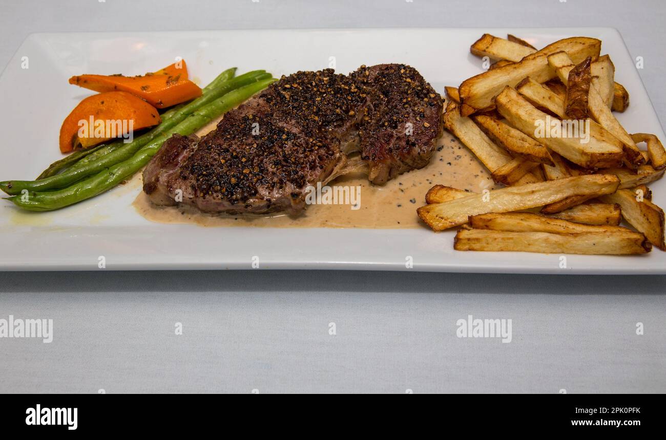 Abendessen mit Steak und Pommes frites für eine Person Stockfoto