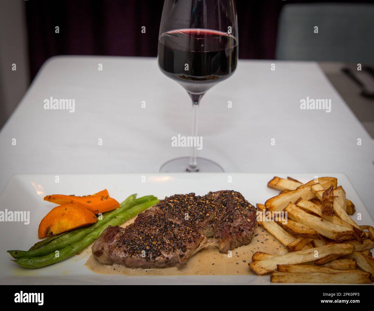 Steak- und Weindinner mit Gemüse und Pommes frites Stockfoto