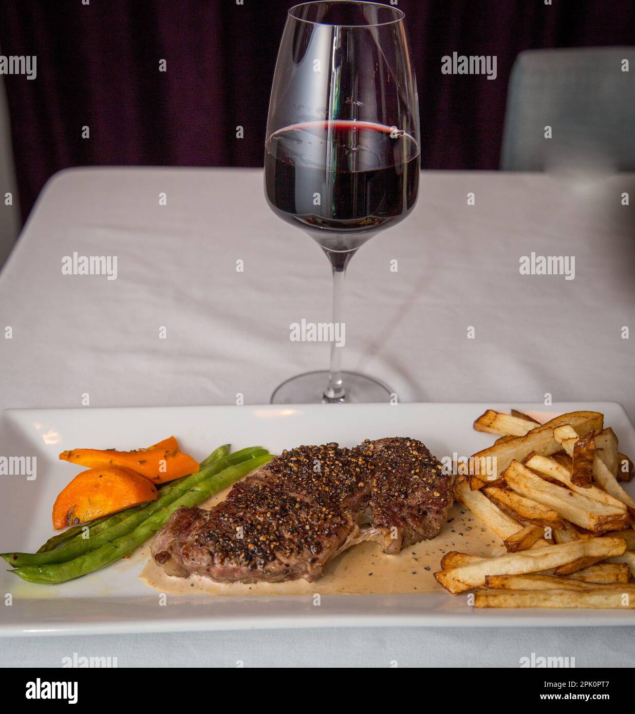 Steak- und Weinabendessen mit Gemüse und Pommes Frites Stockfoto