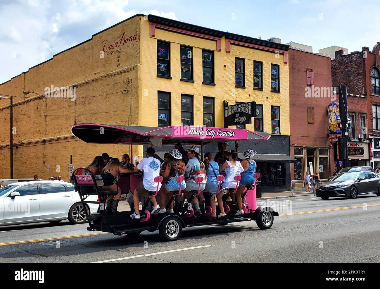 Nashville, Tennessee, USA - 26. Juni 2022 - Passagiere in der rosafarbenen Farbe des Music City Crawlers, die entlang der Bars und Restaurants auf der Broadway Str Stockfoto