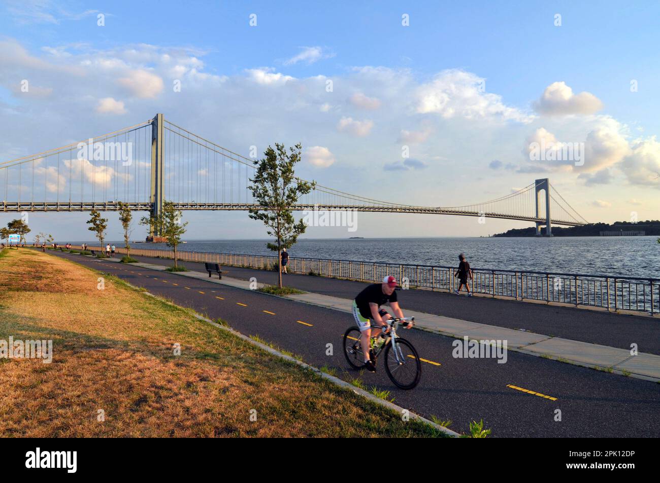 Radfahren auf der Bay Ridge Promenade mit der Verrazzano-Brücke im Hintergrund. Brooklyn, New York City, New York, USA. Stockfoto