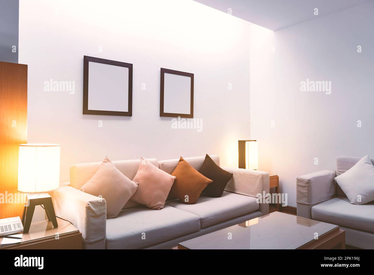 Luxuriöses Wohnzimmer in der Nacht, ein warmes weißes Wohnzimmer. Mit dem Licht von der elektrischen Lampe. Stockfoto