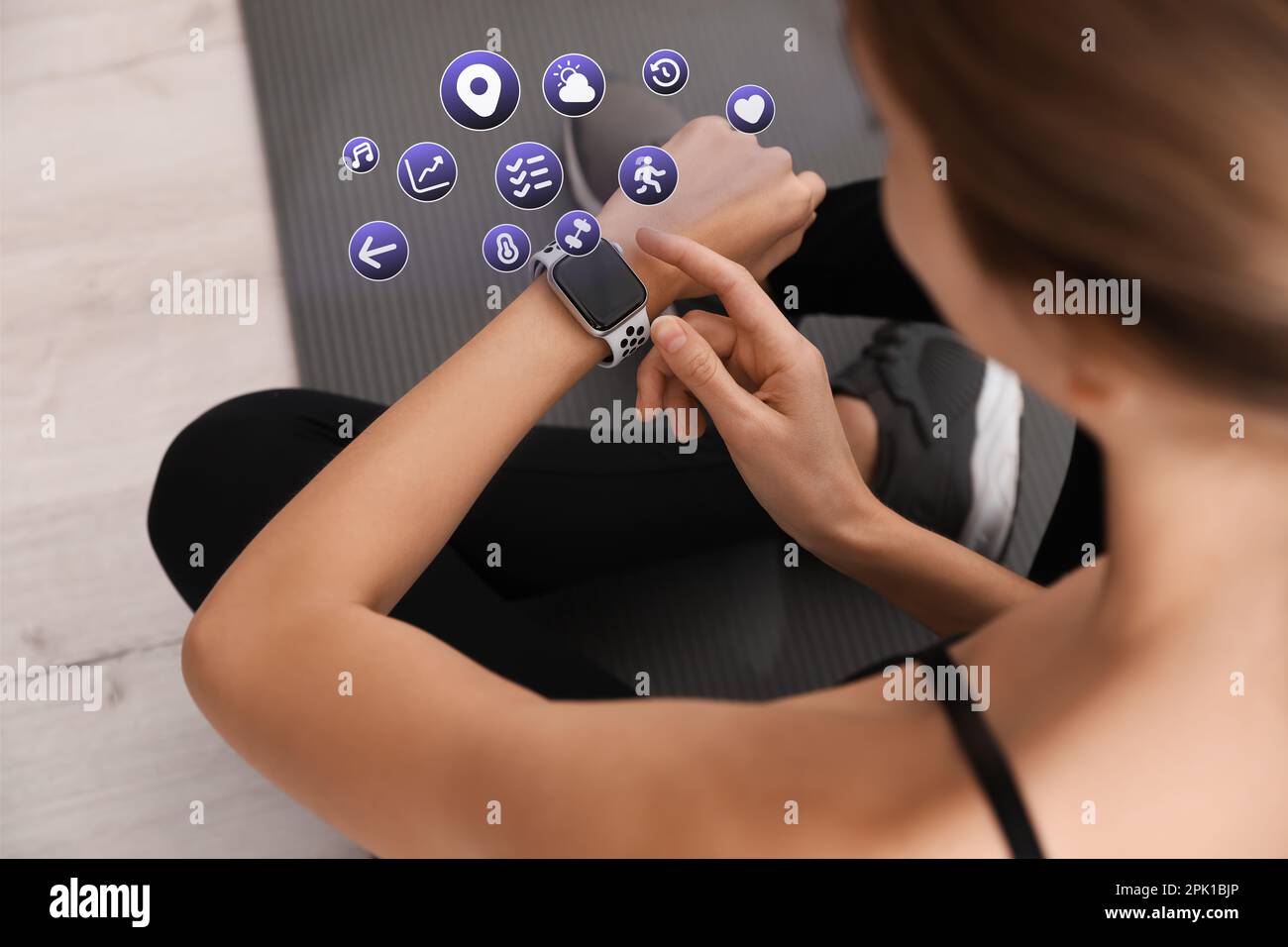 Junge Frau, die Fitness-Tracker während des Trainings im Innenbereich benutzt, Nahaufnahme Stockfoto