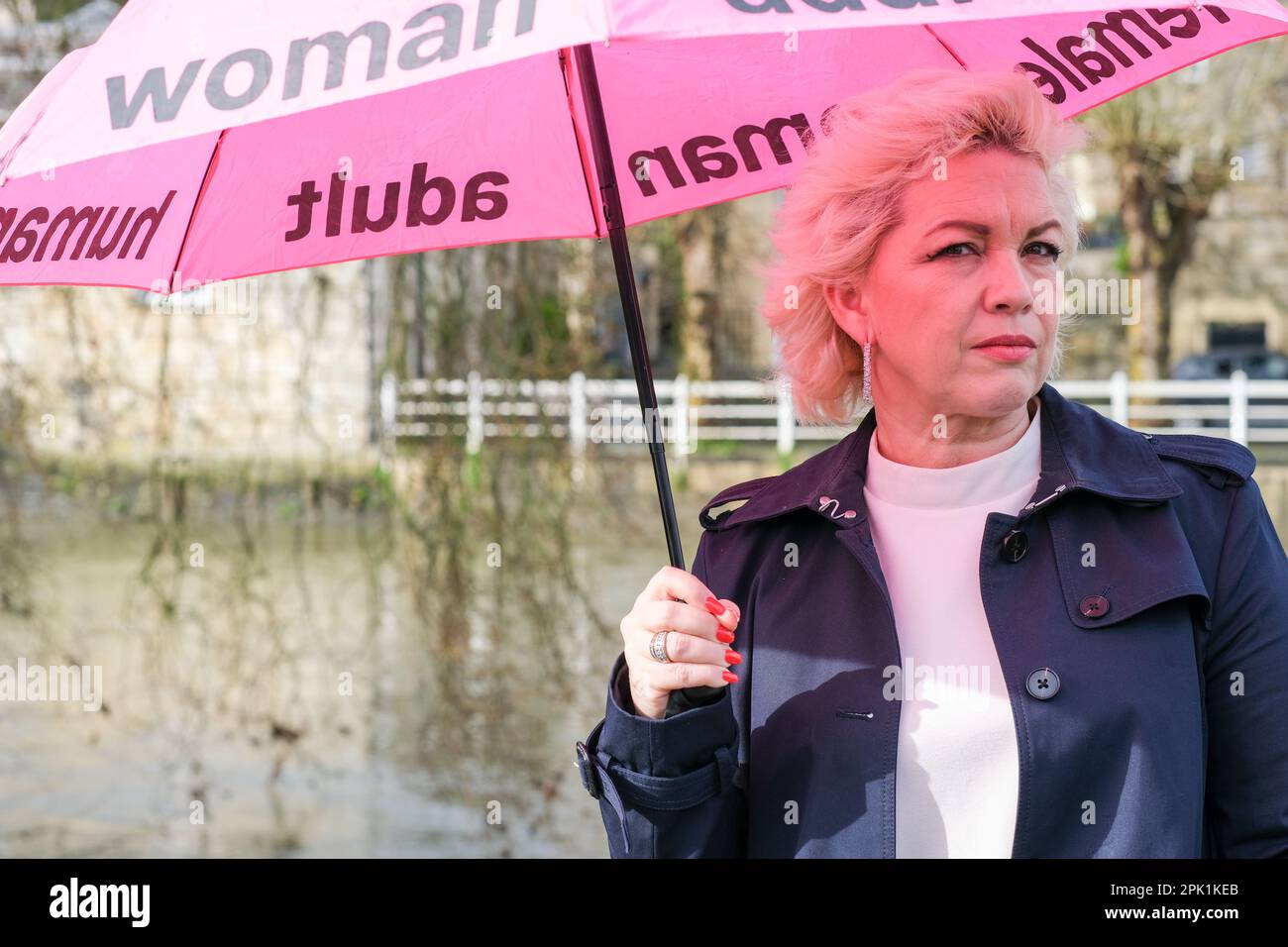 Kellie-Jay Keen, auch bekannt als Posie Parker, ein Anti-Transgender-Aktivist mit einem rosafarbenen Regenschirm mit dem Logo „Woman, adult, female“ in England im April 2023 Stockfoto