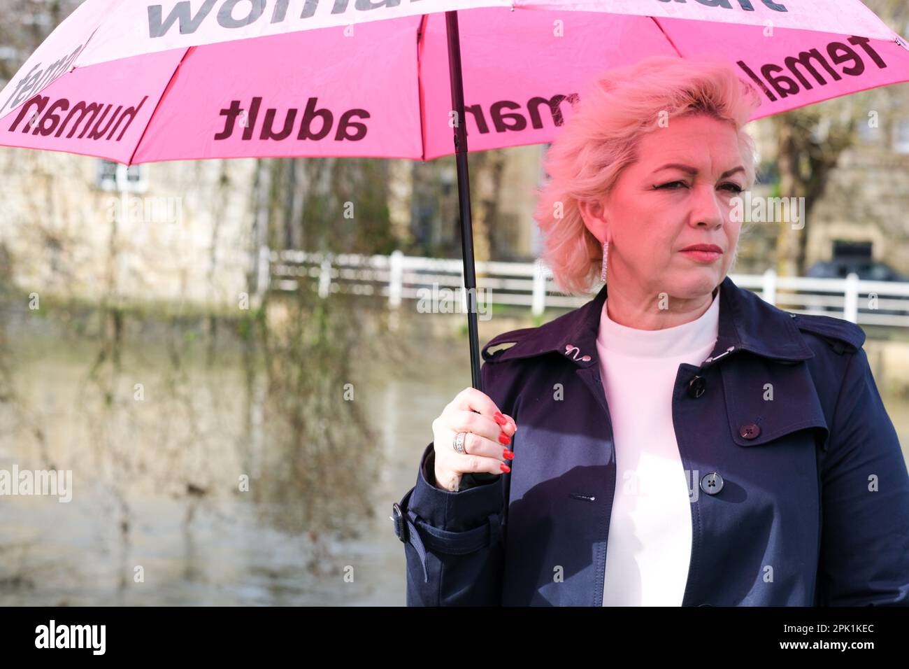 Kellie-Jay Keen, auch bekannt als Posie Parker, ein Anti-Transgender-Aktivist mit einem rosafarbenen Regenschirm mit dem Logo „Woman, adult, female“ in England im April 2023 Stockfoto