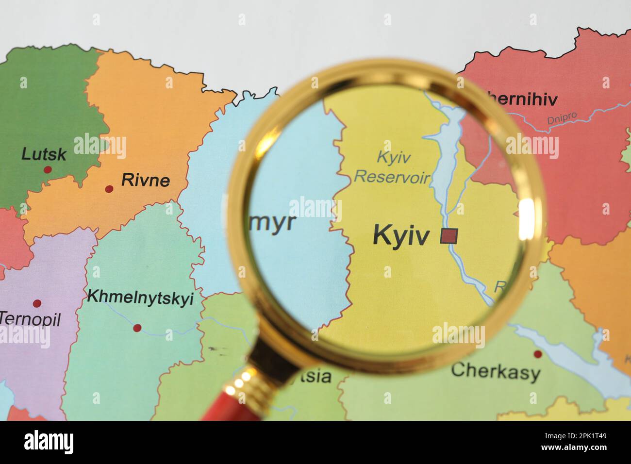 Goldenes Vergrößerungsglas über der Region Kiew auf der Karte der Ukraine, Nahaufnahme Stockfoto