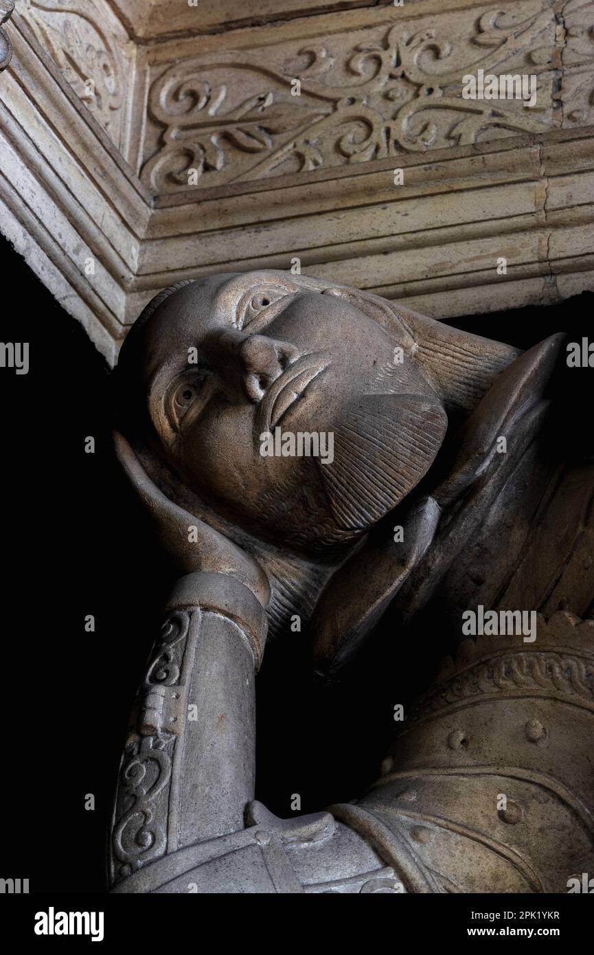 Über die Jahrhunderte träumen… Jakobinemann Sir Edmund Fettiplace (1554-1613) legt seinen Kopf auf seine Hand, während er auf die Kanzeldecke in der St. Mary's Parish Church im Windrush Valley blickt, Cotswolds, Dorf Swinbrook, Oxfordshire, England, UK. Sir Edmund beauftragte das einzigartige Stufendenkmal, auf dem er mit seinem Großvater Alexander und seinem Vater William liegt. Stockfoto