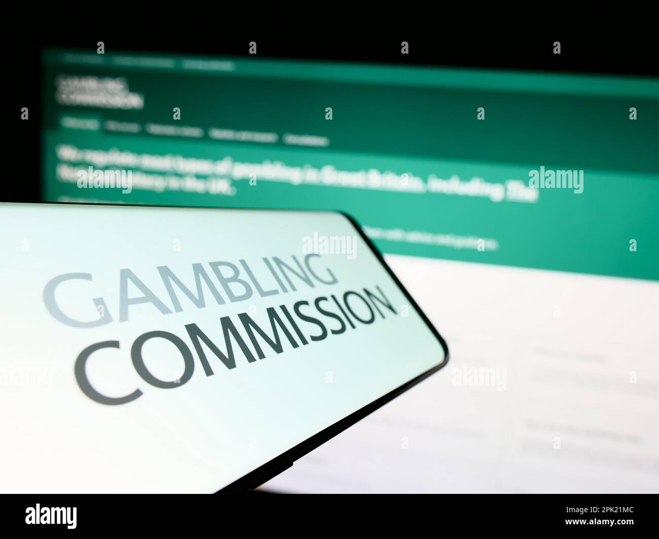 Smartphone mit Logo der britischen Glücksspielkommission auf dem Bildschirm vor der Website. Fokus auf die Mitte links des Telefondisplays. Stockfoto