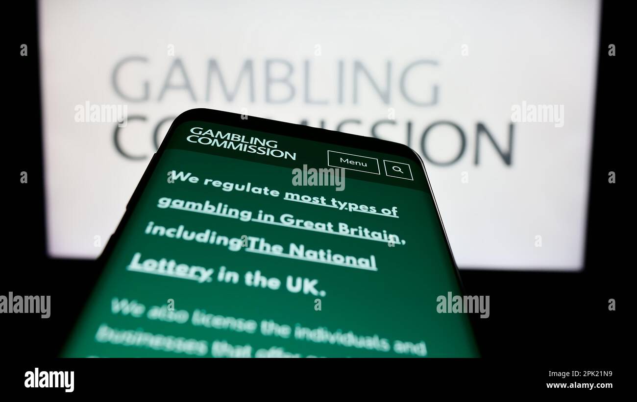 Smartphone mit Webseite der britischen Public Body Gambling Commission auf dem Bildschirm vor dem Logo. Fokus auf oberer linker Seite des Telefondisplays. Stockfoto