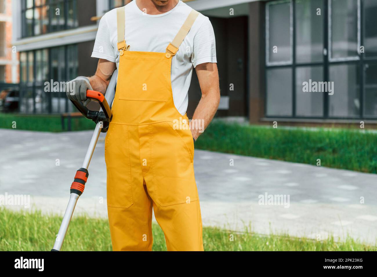Nahaufnahme. Ein Mann mäht das Gras mit einem Rasenmäher im Freien im Hof Stockfoto