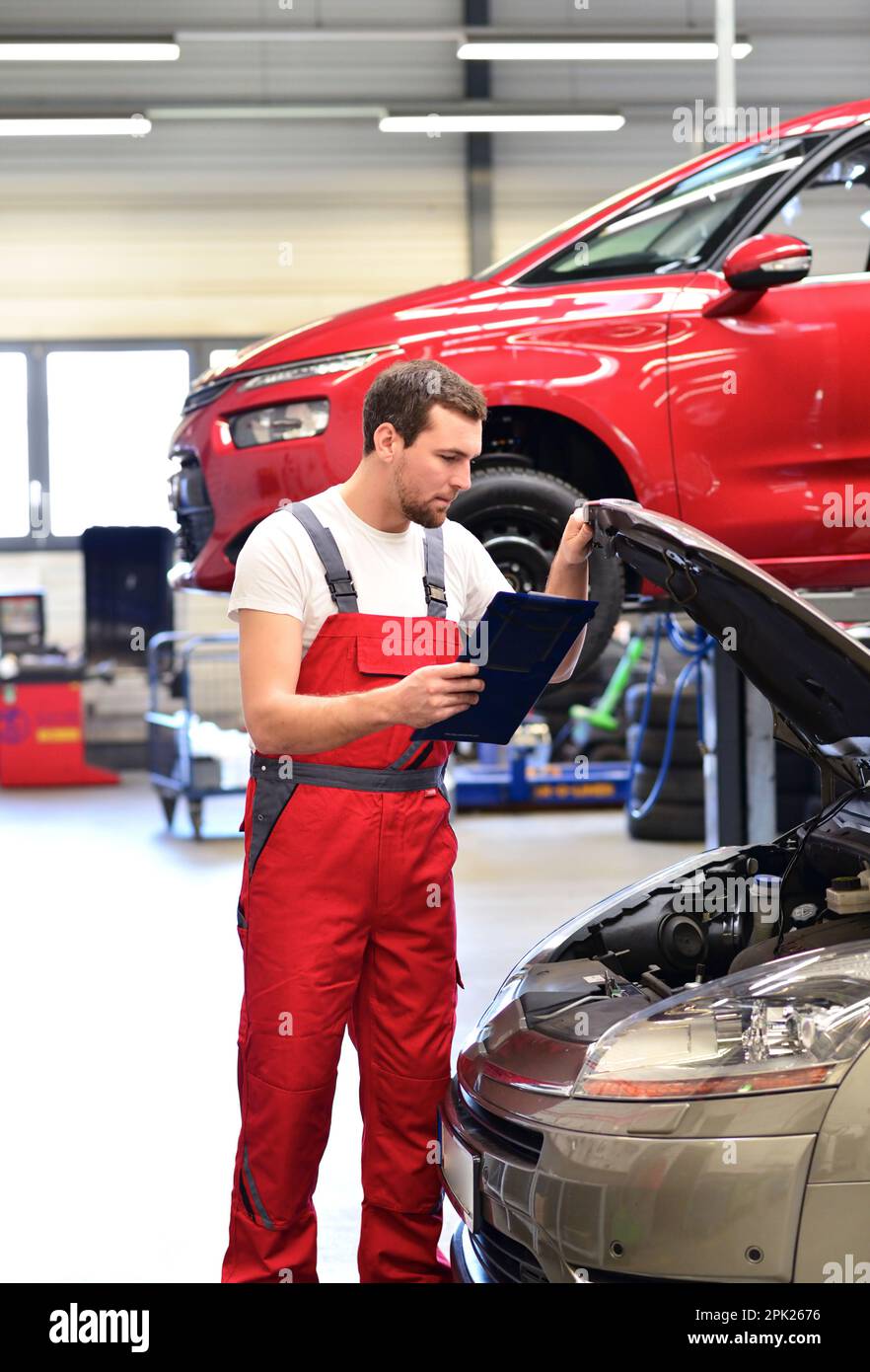 Kfz-Mechaniker in einer Werkstatt die Reparatur eines Fahrzeugs Stockfoto