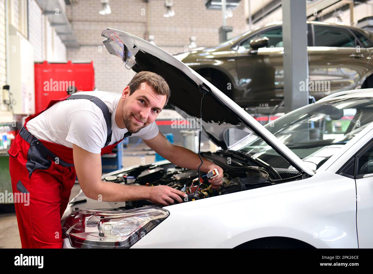 Porträt eines freundlichen Mechaniker in der Werkstatt in Arbeitskleidung - Job Instandsetzung von Fahrzeugen Stockfoto