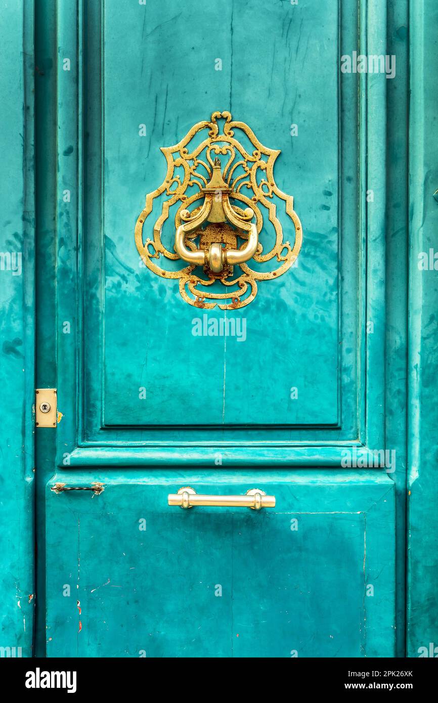 Ein alter goldener Türklopfer im Vintage-Stil an einer hellblauen türkisfarbenen Tür in Frankreich Stockfoto