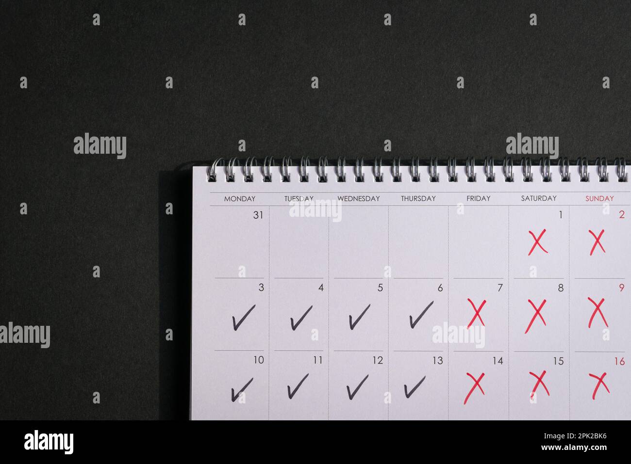 Kalender mit Häkchen und Kreuzen, der das Konzept der vier-Tage-Arbeitswoche darstellt. Speicherplatz kopieren. Stockfoto