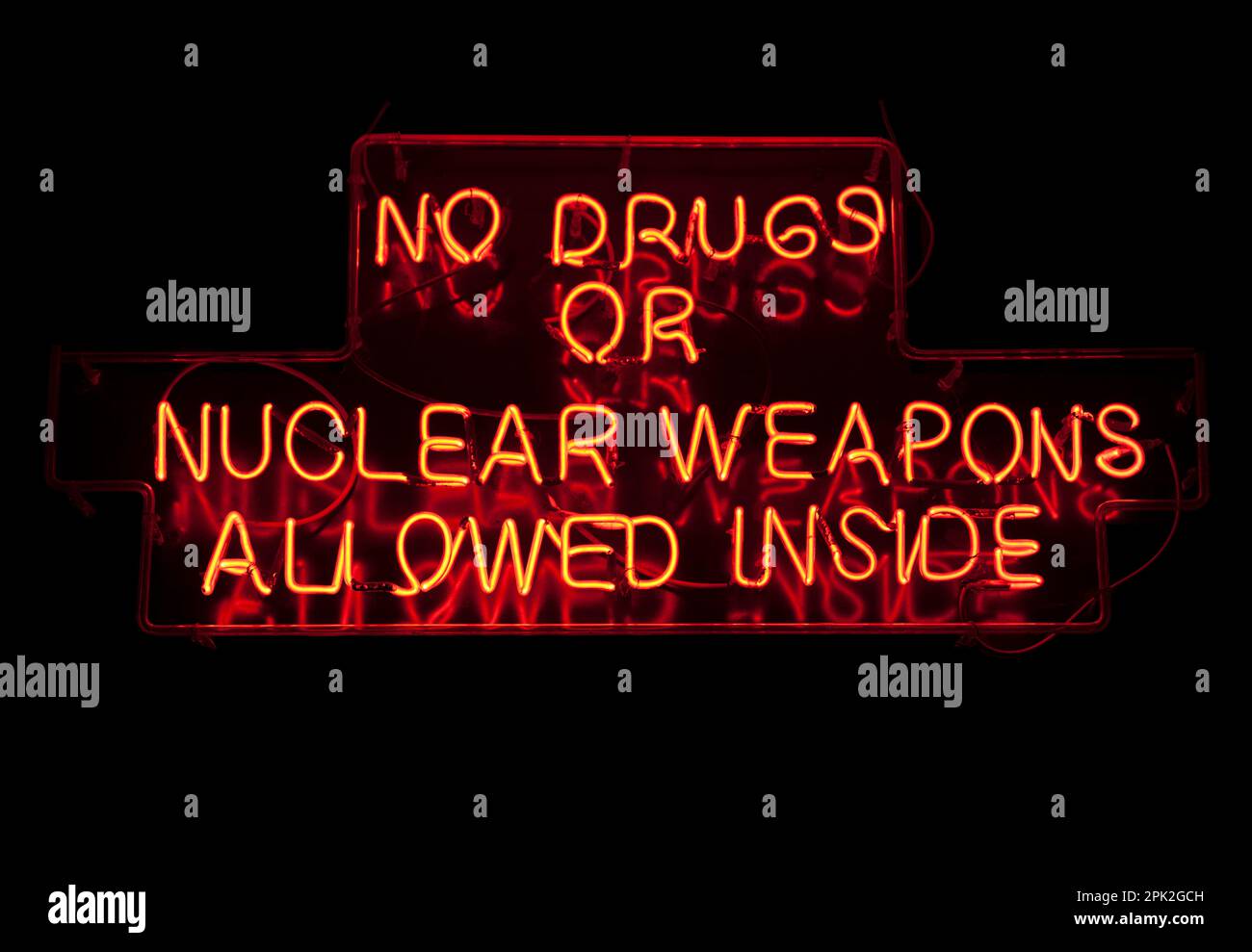 Ein lustiges Neonlicht in Form des Warnhinweises: "Keine Drogen oder Atomwaffen dürfen hinein". Stockfoto
