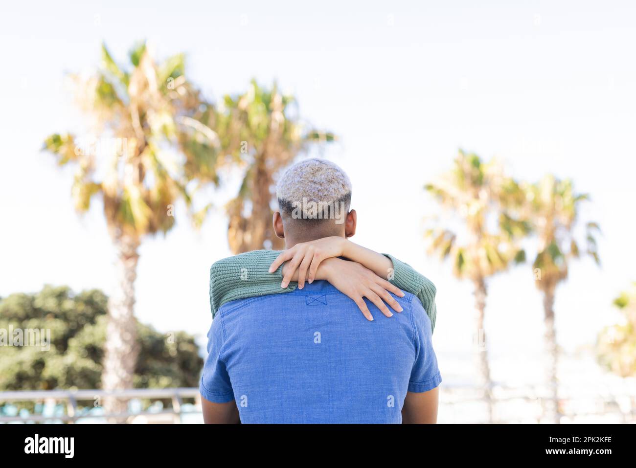 Ein vielseitiges Paar, das Zeit miteinander verbringt und die Promenade am Meer umarmt Stockfoto