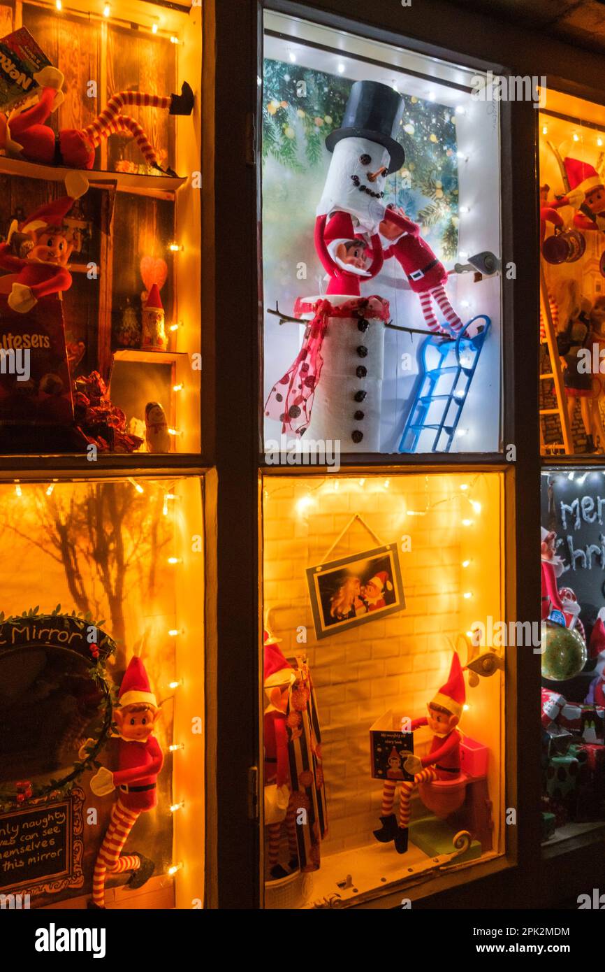 Ein Hausfenster, das in Abschnitte unterteilt ist, mit weihnachtsszenen in jeder. Stockfoto