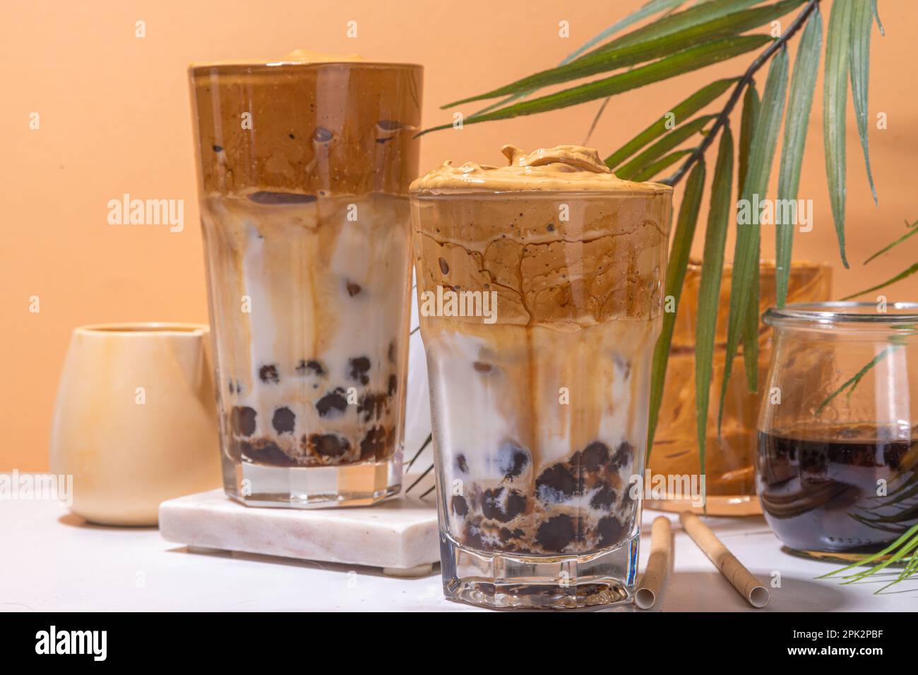 Boba dalgona Kaffee. Trendiges asiatisches Latte-Morgengetränk mit Instant-Kaffee und Tapioka-Perlkugeln, thailändisches Schaumcocktail-Glas im Sommer in der Sonne Stockfoto